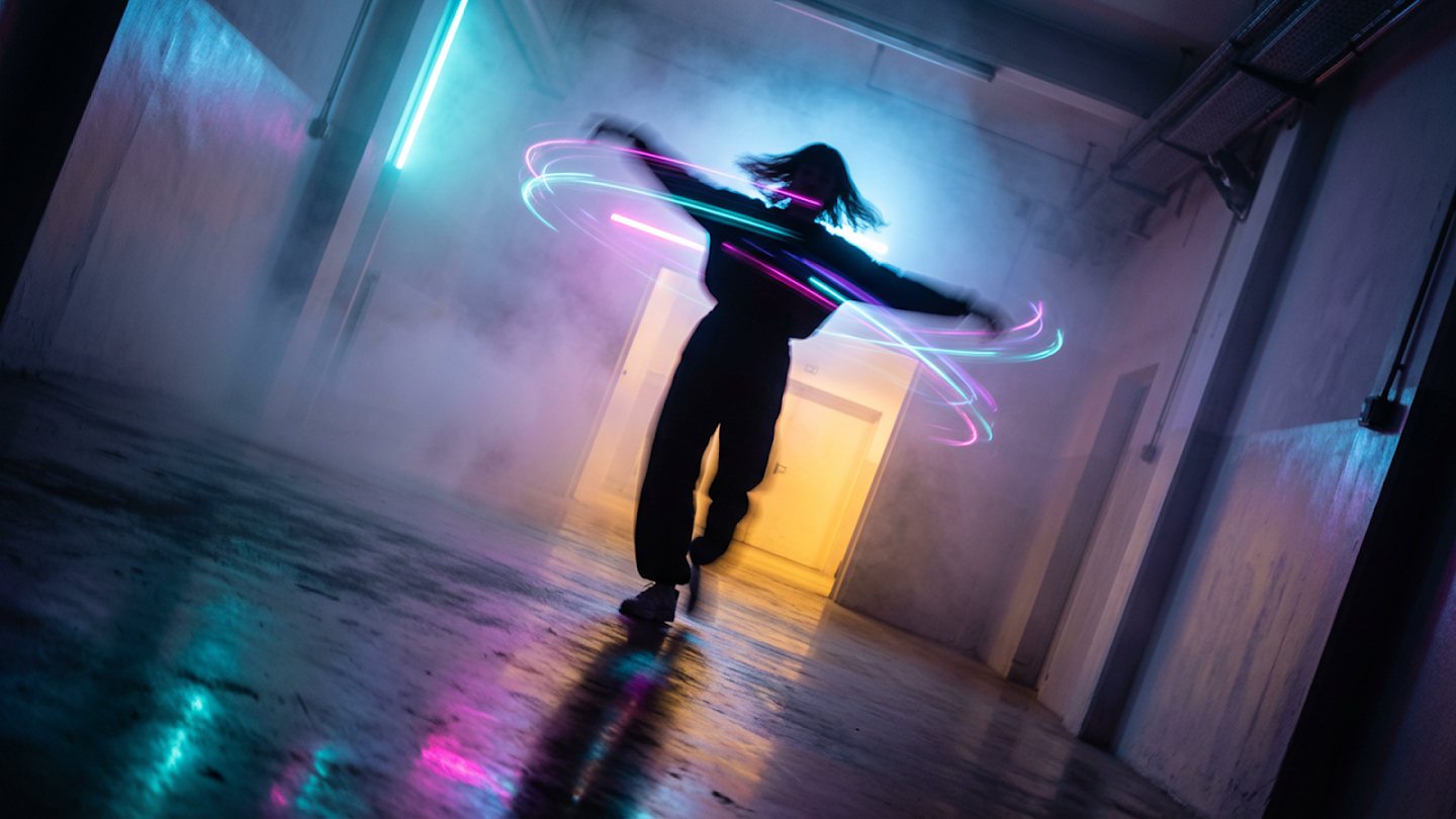 Long-exposure dancer surrounded by swirling neon pink and blue light trails generated by Nano Banana Pro